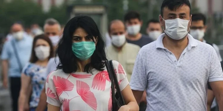 Covid-19 vaka sayısı artarken toplu taşımada maske takan bir kadın, hastalıktan korunmak için önlem alıyor.